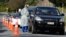 Medical staff prepare take a COVID-19 test from a visitor to a drive through community based assessment center in Christchurch, New Zealand, Aug. 13, 2020.