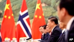 FILE - Chinese President Xi Jinping speaks to Norwegian Prime Minister Erna Solberg at the Great Hall of People in Beijing, China, April 10, 2017. In another sign that their relationship was thawing, the two countries have resumed talks on a bilateral free trade deal, Norway's Industry Ministry said Thursday.