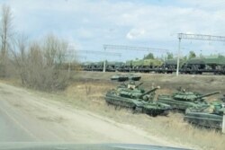 A still image from video shows tanks and military vehicles in Maslovka, Voronezh Region, Russia, Apr. 6, 2021. (Video by Reuters. This image was processed by Reuters to enhance quality)