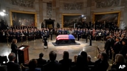 Vice President Kamala Harris, left, delivers a eulogy for former President Jimmy Carter as he lies in state during a ceremony in the Capitol, Jan. 7, 2025, in Washington. Carter died Dec. 29 at the age of 100. 