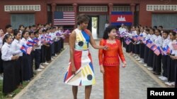 U.S. first lady Michelle Obama (L) walks with Bun Rany, Cambodia's first lady during a visit to promote girls' education at Hun Sen Prasaat Bankong high school on the outskirts of Siem Reap, March 21, 2015. 