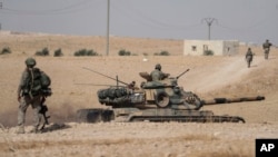 FILE - FILE - Turkish tanks and troops are deployed near the Syrian town of Manbij, Syria, Oct. 15, 2019. The area continues to experience violence, with Turkish-backed factions clashing with U.S.-backed Kurdish-led Syrian Democratic Forces.