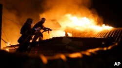 Firefighters extinguish fire at a house destroyed by night-long shelling in Donetsk, eastern Ukraine, Aug. 16, 2015. 