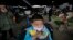 A child wears a mask near the closed poultry section at the Huhai agricultural market where the H7N9 bird flu was detected by authority in Shanghai, China, Apr. 9, 2013. 