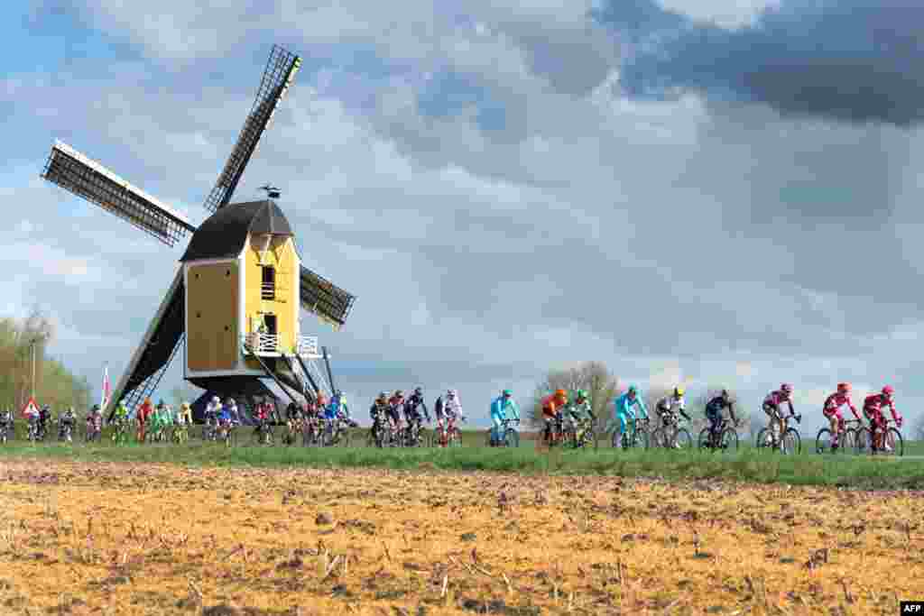 The pack compete in front of the Hubertus mill during the Amstel Gold Race in Beek, The Netherlands.