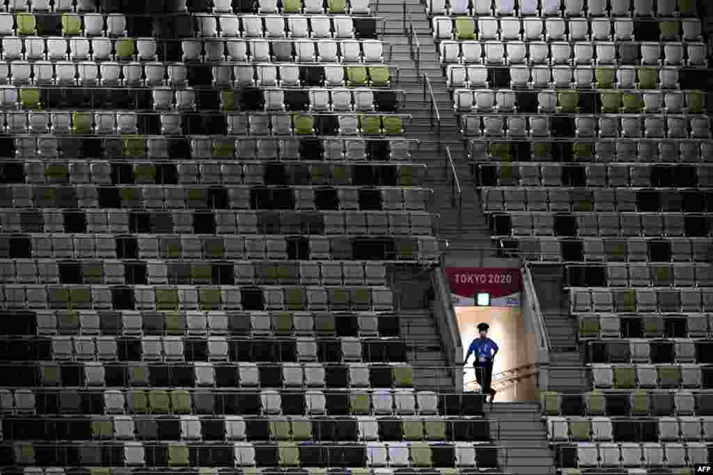 A police officer is seen in the empty stands ahead of the opening ceremony of the Tokyo 2020 Olympic Games, at the Olympic Stadium, in Tokyo, on July 23, 2021.