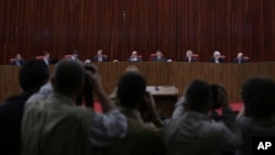 FILE - Judges sit in the Superior Electoral Court during the judgment phase of a trial involving allegations that the 2014 Rousseff-Temer ticket received illegal campaign financing in Brasilia, Brazil, June 6, 2017. 
