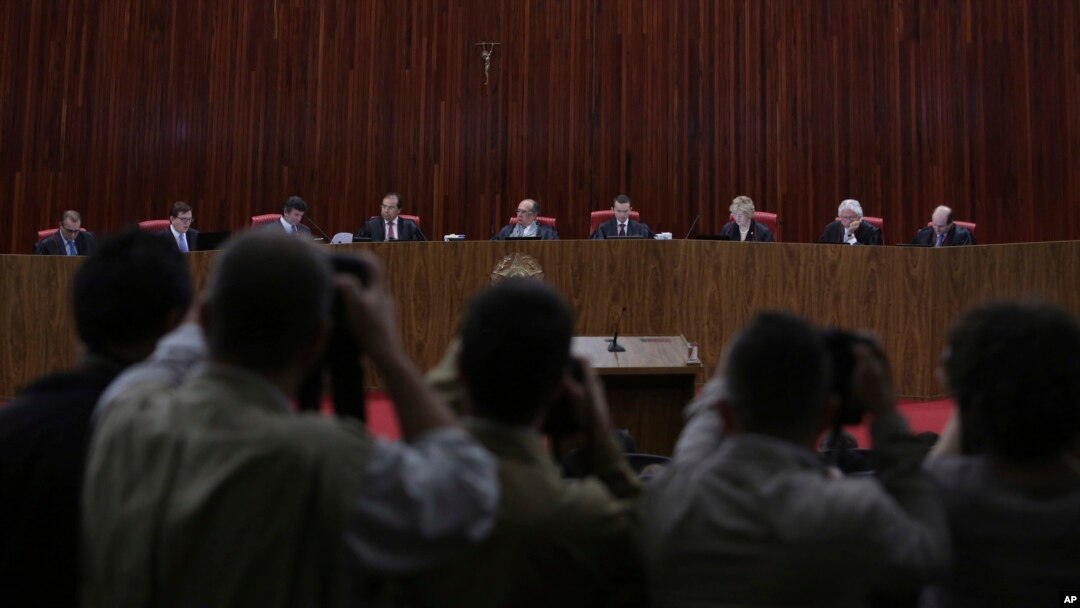 FILE - Judges sit in the Superior Electoral Court during the judgment phase of a trial involving allegations that the 2014 Rousseff-Temer ticket received illegal campaign financing in Brasilia, Brazil, June 6, 2017. 
