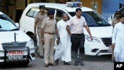 Franco Mulakkal, bishop of the Indian city of Jalandhar, center, whom a nun has accused of rape, leaves after appearing for questioning by police in Kochi, India, Sept. 19, 2018. The bishop has denied the accusation. 
