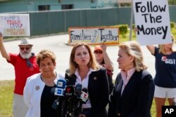 Rep. Debbie Mucarsel-Powell, D-Fla., center, speaks to members of the media about her tour of the Homestead Temporary Shelter for Unaccompanied Children, as Rep. Donna Shalala, D-Fla., left, and Rep. Sylvia Garcia, D-Texas, right, look on, in Homestead, Fla., Feb. 19, 2019.