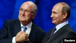 FIFA's President Sepp Blatter shakes hands with Russia's President Vladimir Putin (R) during the preliminary draw for the 2018 FIFA World Cup at Konstantin Palace in St. Petersburg, July 25, 2015.