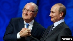 FILE - Now suspended FIFA President Sepp Blatter (L) shakes hands with Russian President Vladimir Putin during the preliminary draw for the 2018 FIFA World Cup at Konstantin Palace in St. Petersburg, July 25, 2015.