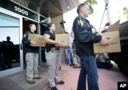 Federal agents carry out boxes of evidence taken from the headquarters of the Confederation of North, Central America and Caribbean Association Football (CONCACAF,) May 27, 2015, in Miami Beach, Fla.