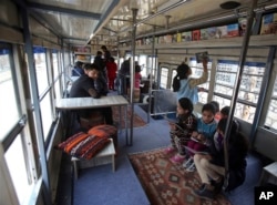 Afghan children read books inside a library on wheels, in Kabul, Afghanistan, March 10, 2018.
