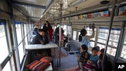 Afghan children read books inside a library on wheels, in Kabul, Afghanistan, March 10, 2018.