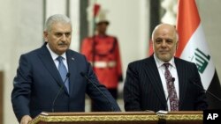 Iraq's Prime Minister Haider al-Abadi, right, and Turkish Prime Minister Binali Yildirim speak to reporters after their talk in Baghdad, Iraq,, Jan. 7, 2017. 