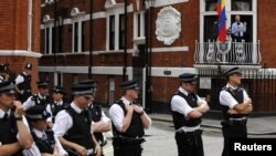 Polisi Inggris berjaga-jaga di luar Kedutaan Besar Ekuador di London, sementara pendiri WikiLeaks Julian Assange berbicara dari balkon kedutaan (19/8). 