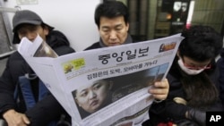  FILE - A South Korean man reads a newspaper with the headline reporting North Korea's rocket launch while traveling on a subway in Seoul, South Korea, Dec. 13, 2012.