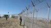 FILE - Pakistani soldiers stand guard at a fence between Pakistan and Afghanistan at Angore Adda, Pakistan, Oct. 18, 2017.