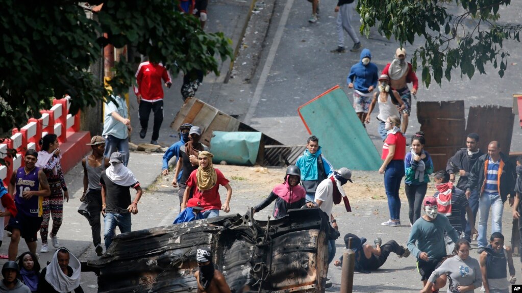 Los manifestantes antigubernamentales se enfrentan a las fuerzas de seguridad cuando muestran su apoyo a un aparente motín por parte de una unidad de la Guardia Nacional en el barrio de Cotiza en Caracas, Venezuela.