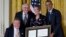 President Barack Obama, right, with former President George H. W. Bush, left, present the 5,000th Daily Point of Light Award to Floyd Hammer and Kathy Hamilton, center, from Union, Iowa, in the East Room of the White House in Washington, Jul. 15, 2013.
