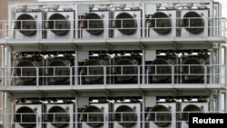 FILE - A facility for capturing CO2 from air of Swiss Climeworks AG is placed on the roof of a waste incinerating plant in Hinwil, Switzerland, July 18, 2017. 