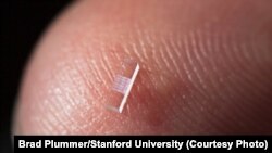 Particle accelerator on a nanostructured glass chip is smaller than a grain of rice. (Brad Plummer/Stanford University)