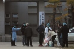 지난 20일 중국 후베이성 우한의 병원에서 의료 관계자가 환자의 가족들의 방문을 제한시키고 있다.