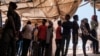 FILE - Eritrean refugees queue during a distribution of items organized the UNHCR at Mai Aini Refugee camp, in Ethiopia, Jan. 30, 2021.