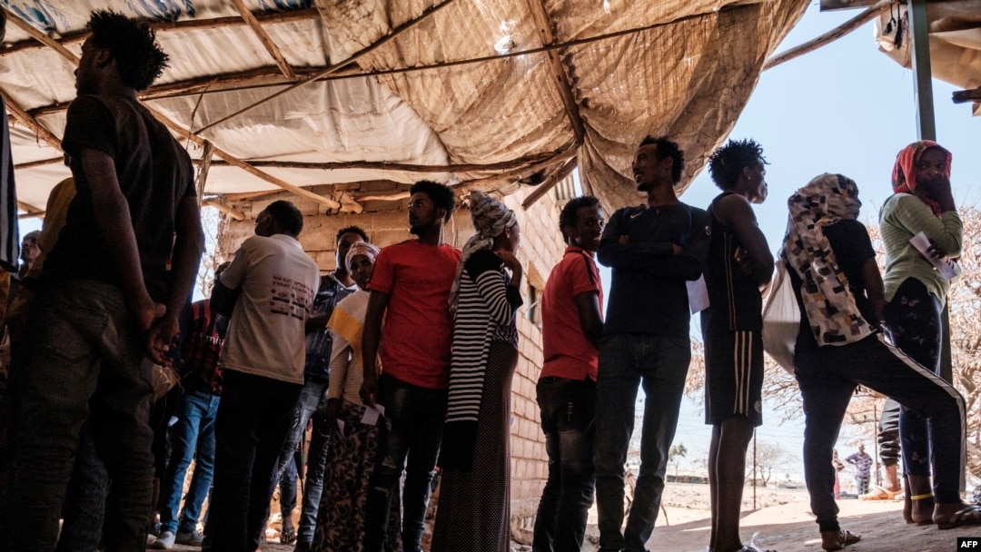 FILE - Eritrean refugees queue during a distribution of items organized the UNHCR at Mai Aini Refugee camp, in Ethiopia, Jan. 30, 2021.