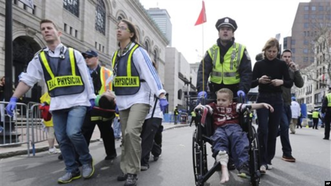 Polisi dan petugas medis membawa para korban luka akibat ledakan bom di Boston (15/4). (Foto: AP)