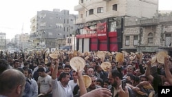 In this citizen journalism image made on a mobile phone, taken Tuesday, May 3, 2011, Syrian men carry pieces of bread during a protest against Syrian President Bashar Assad's regime, in the coastal town of Banias