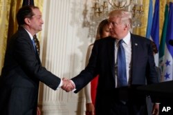 President Donald Trump shakes hands with Secretary of Labor Alex Acosta during a Hispanic Heritage Month event in the East Room of the White House, Oct. 6, 2017, in Washington.