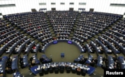 FILE - Members of the European Parliament take part in a voting session in Strasbourg, France, April 5, 2017.