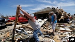 Workers clear damage from Oklahoma tornado.