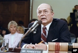 Former National Security Advisor John Poindexter, contradicting President Reagan, tells Iran-Contra committees in Washington on Wednesday, July 15, 1987 that the President initially approved selling arms to Iran in late 1985 in a straight-arms for hostages.
