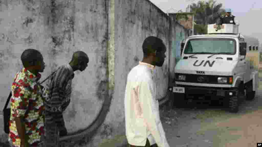 Des manifestants se cachent à l&#39;arrière d&#39;in véhicule de l&#39;ONU alors que la police tire et lance des gaz lacrymogènes lors d&#39;une manifestation, lundi 10 Janvier, 2005. . (AP Photo / John Bompengo) 