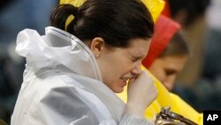 FILE - A fan sitting in the rain during a long rain delay sneezes before the start of a baseball game between the Florida Marlins and New York Mets at Citi Field, New York, Monday, May 16, 2011. (AP Photo/Paul J. Bereswill)