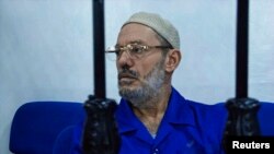 Ahmed Ibrahim, former minister in the government of Moammar Gadhafi, sits behind bars during a hearing in Misrata, July 31, 2013.