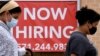 FILE - Women walk past by a 'Now Hiring' sign outside a store in Arlington, Virginia, Aug. 16, 2021.. 