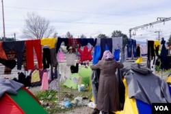 Refugees at the Idomeni encampment try to dry out clothing and bedding between rainstorms. (J. Dettmer/VOA)