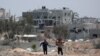 Sejumlah warga Palestina berjalan melewati bangunan-bangunan yang hancur di sekitar Rumah Sakit Nasser di Khan Yunis, di selatan Gaza, pada 24 Maret 2024. (Foto: AFP)