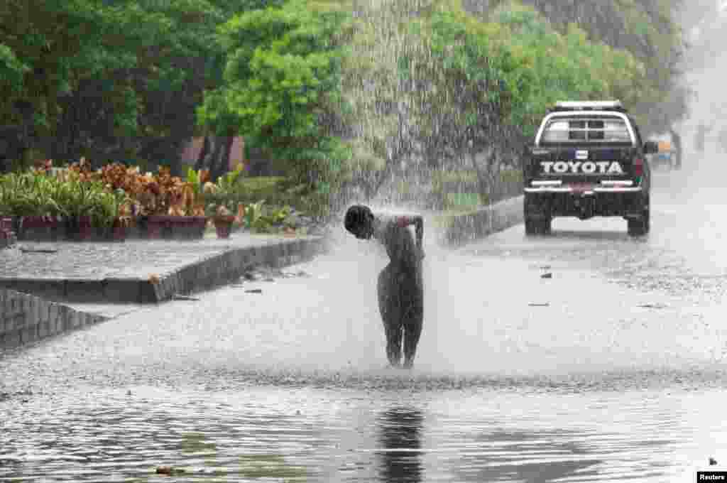 ساون کی بارشوں میں کھیلنے کا مزہ بچپن کے علاوہ بھلا کسی اور عمر میں کہاں آتا ہے۔ لاہور کی شاہراہ پر بارش کی موٹی موٹی بوندوں میں نہانے کے مزے لیتا ایک بچہ۔