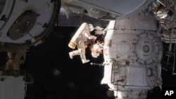 In this image from video made available by NASA, Russian cosmonaut Oleg Kononenko performs a spacewalk outside the International Space Station, Dec. 11, 2018.