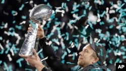 Jwè ekip Philadelphia Eagles, Nick Foles, ki leve trofe Vince Lombardi a anlè apre viktwa ekip la sou New England Patriots dimanch 4 fevriye 2018 la. (Foto: AP/Chris O'Meara).