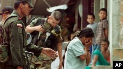 Una mujer llora después de que su hijo fue arrestado por las fuerzas de seguridad durante la Operación Orión en la Comuna 13, el 17 de octubre del 2002