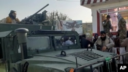 Taliban fighters stand guard in Kunduz city, northern Afghanistan, Aug. 9, 2021. The militants have ramped up their push across much of Afghanistan in recent weeks, turning their guns on provincial capitals.