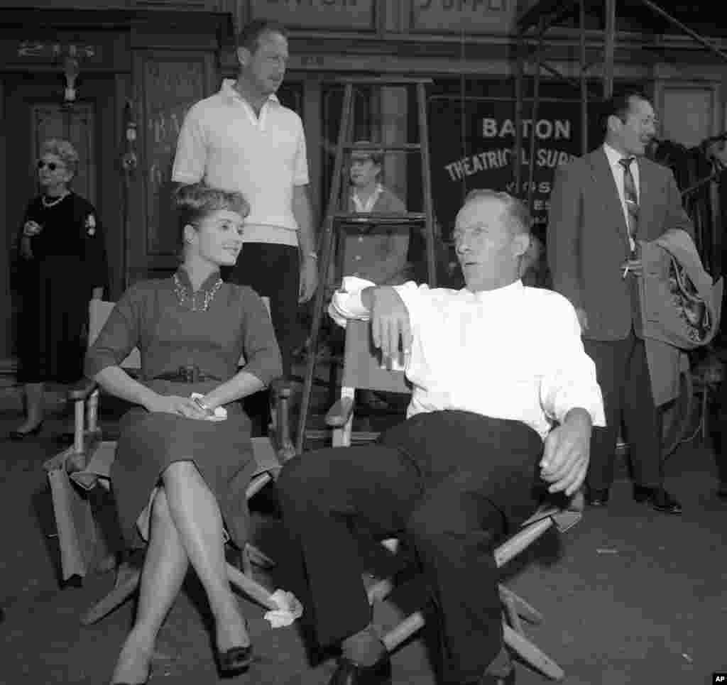  Relaxing between scenes, Bing Crosby talks with Debbie Reynolds on the Hollywood set of "Say One for Me" in Los Angeles, Dec. 29, 1958. They co-star with Robert Wagner in the film.