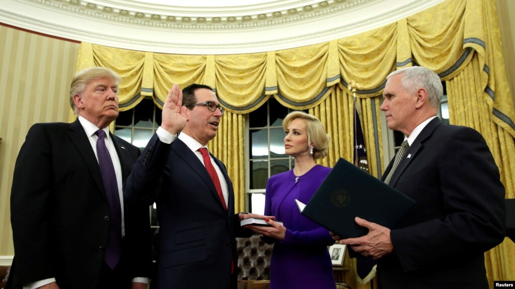 在白宫总统办公室 ，美国财政部长斯蒂夫·努钦在彭斯副总统主持下宣誓就职，她的未婚妻在场（2017年2月13日）。川普总统出席了努钦的就职仪式并称赞他说“我们国家的金融体系真的掌握在能人手里了”