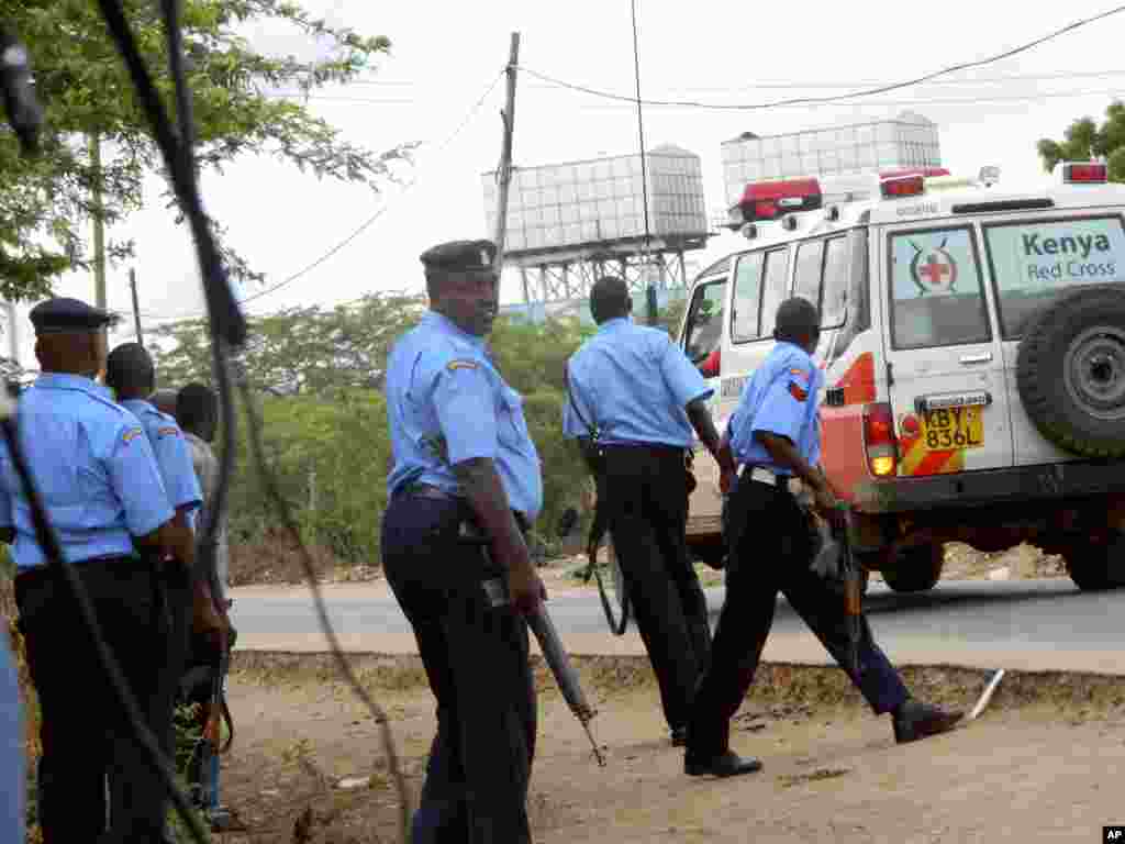 Kenyan police officers take positions during an attack by gunmen outside the Garissa University College as an ambulance carrying the injured are taken to the hospital, in Garissa, April 2, 2015.